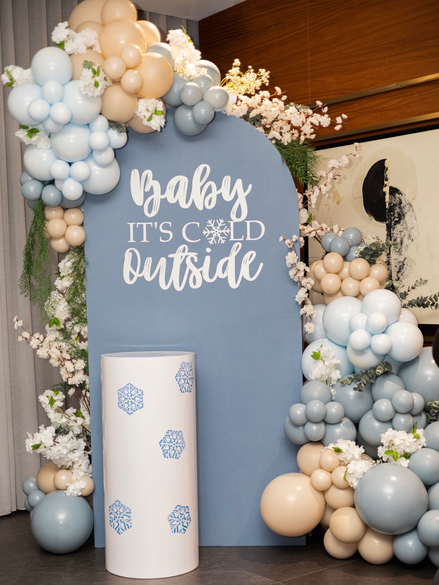 winter baby shower balloon backdrop with blue arch and floral garlands