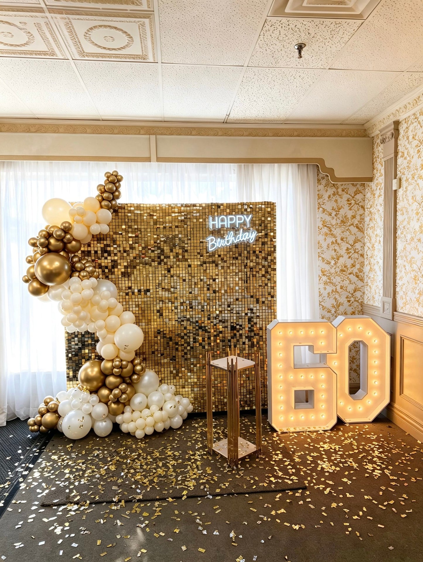 Gold shimmer wall backdrop with gold and white balloon garland, neon Happy Birthday sign and illuminated 60 marquee numbers