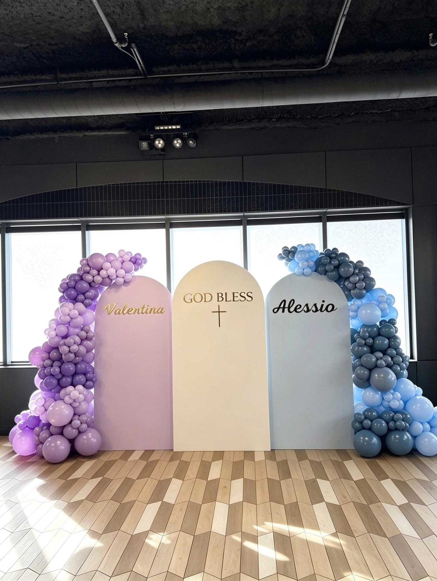 Three-panel twins baptism backdrop with custom names, God Bless sign and lavender and blue balloon garlands