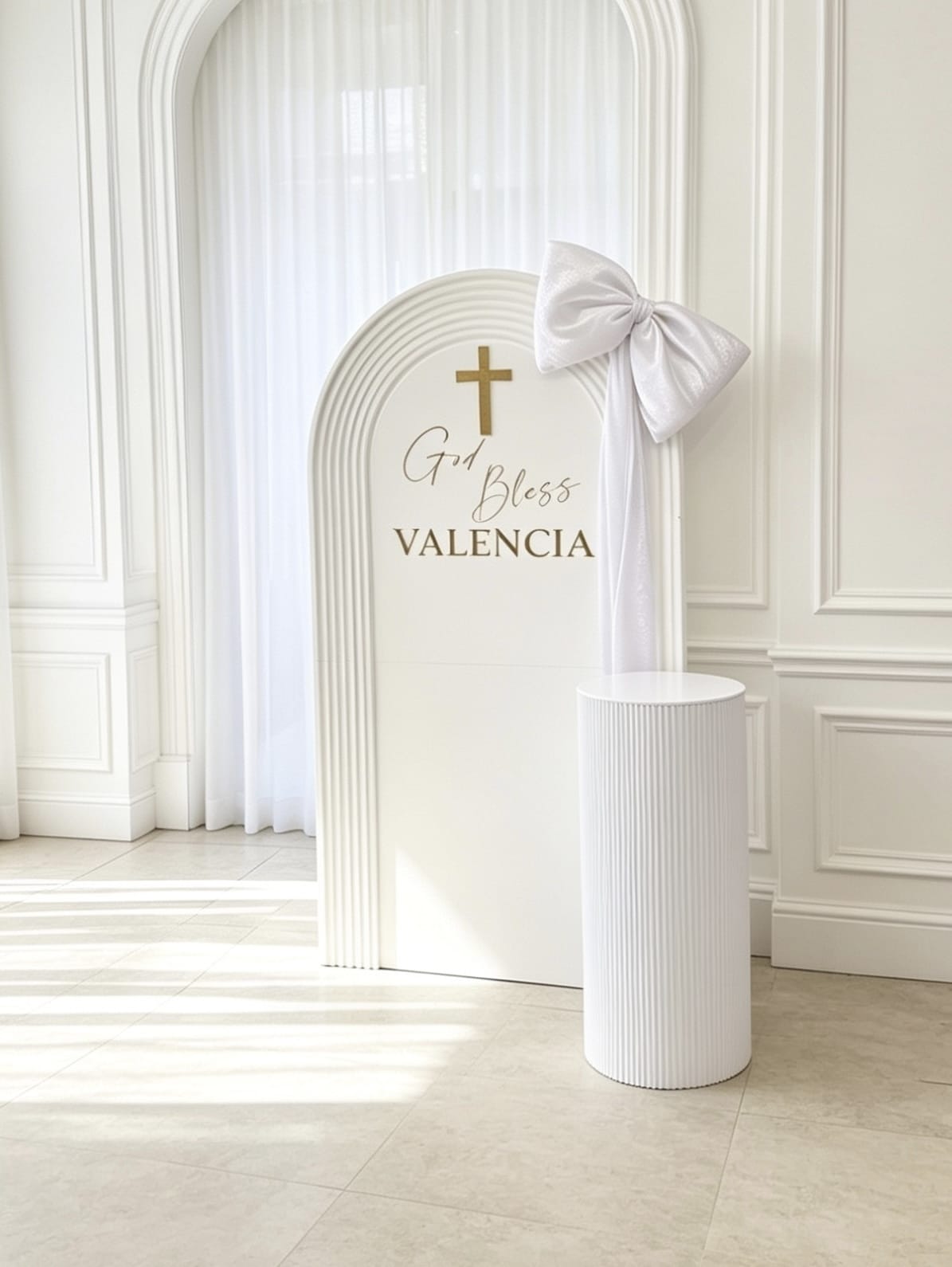 White ripple baptism backdrop with gold cross, custom name, oversized satin bow and matching white pedestal stand.
