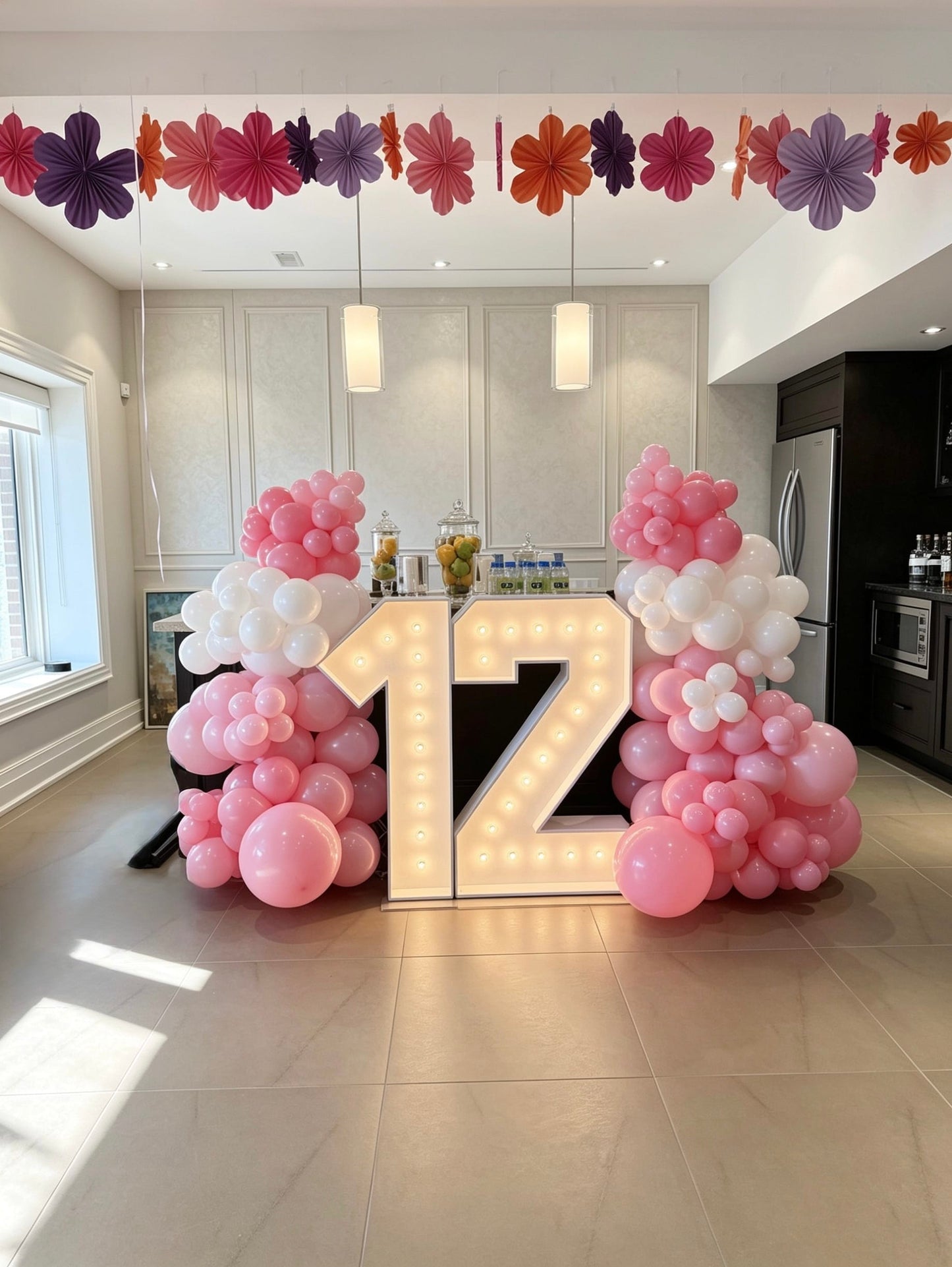 Pink and white balloon garlands with illuminated marquee number 12 setup