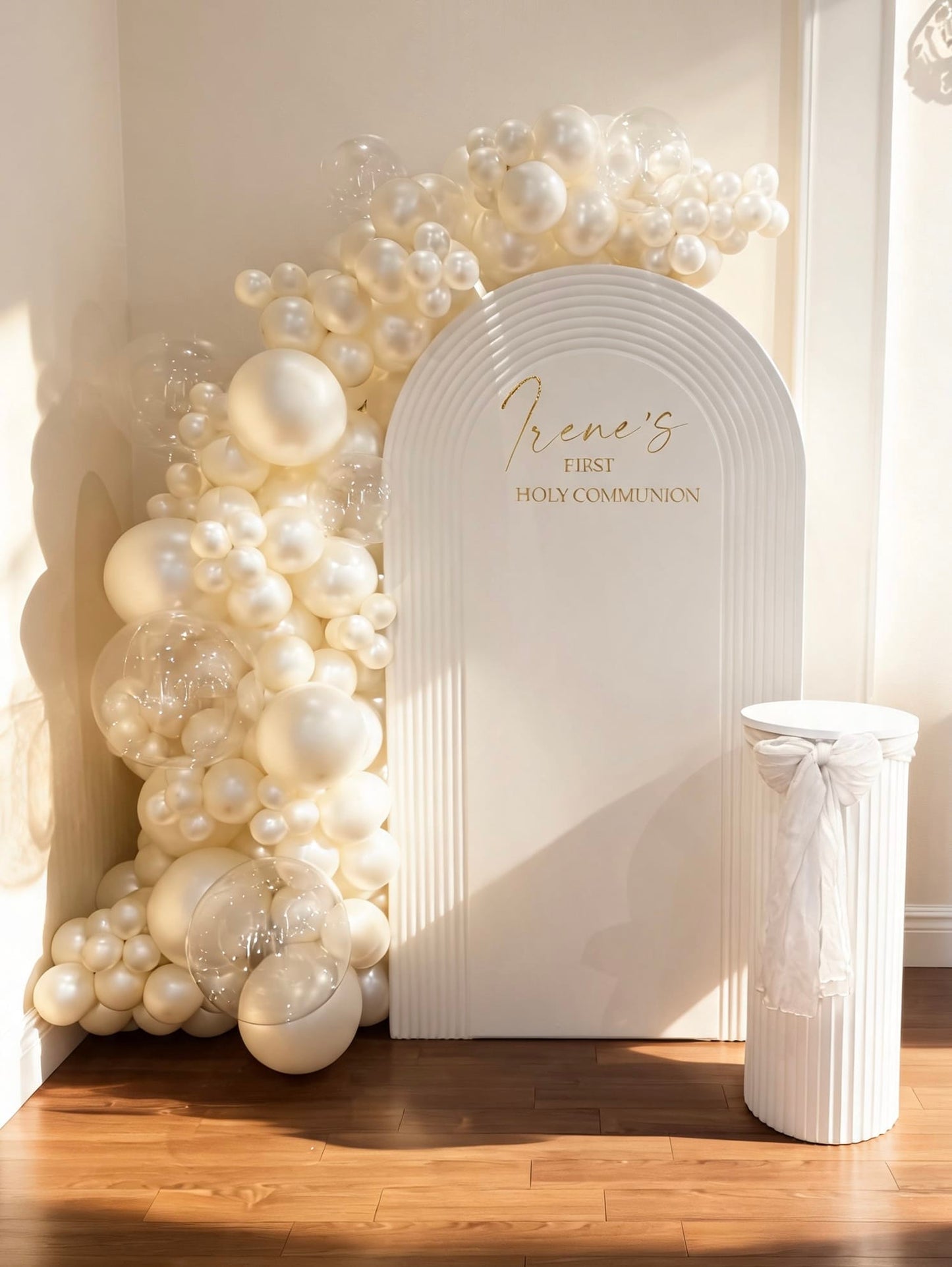 White ripple communion backdrop with ivory pearl balloon garland and custom gold lettering.