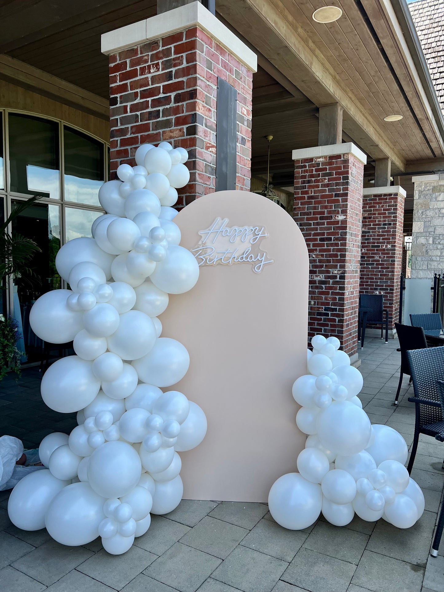 pearl white birthday balloon backdrop with beige arch
