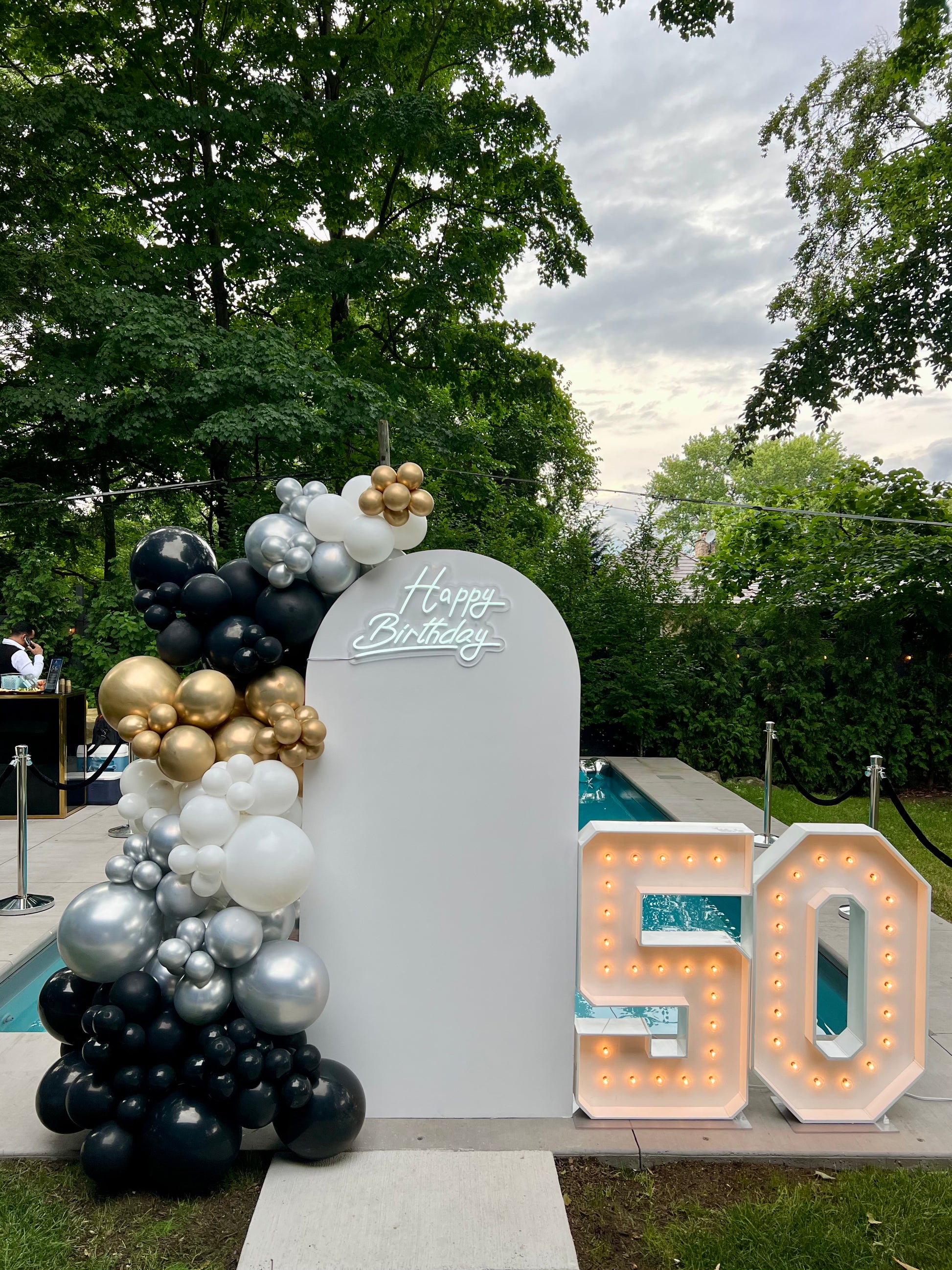 50th birthday white arch backdrop with black gold silver balloon garland