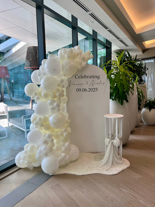 engagement balloon backdrop with white pearl garland and cake table with bow