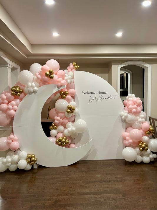 welcome home baby balloon setup with moon backdrop and neutral balloons
