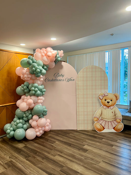 Polo Teddy girl baby shower setup with pink and plaid backdrops, balloon garland, and teddy cut-out.