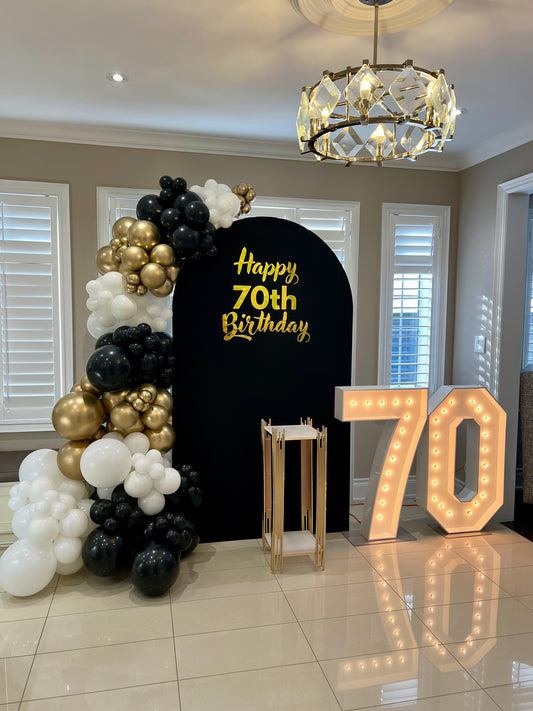 luxury 70th birthday backdrop with black gold balloons and marquee numbers

