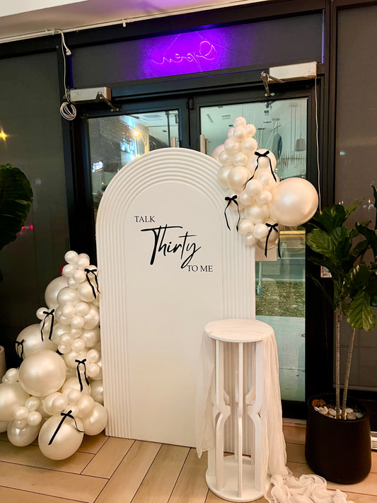 talk 30 to me birthday backdrop with pearl balloon garland and black bows
