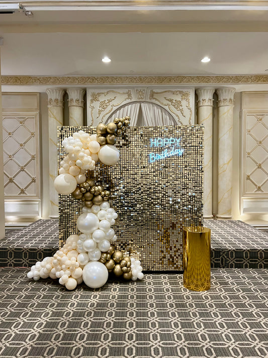 luxury gold shimmer wall birthday setup with pearl balloon garland