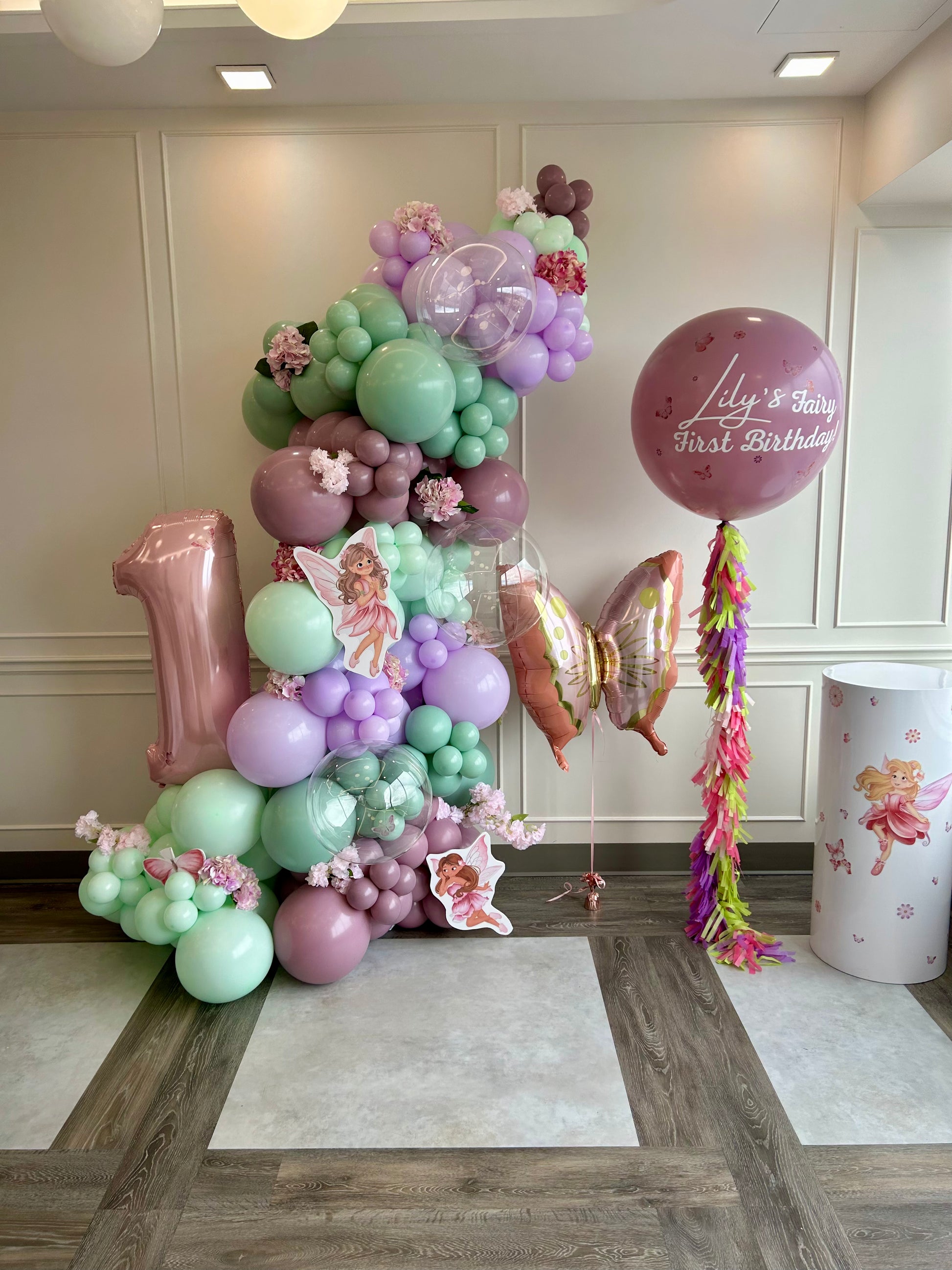 fairy first birthday balloon garland with flowers and custom balloon
