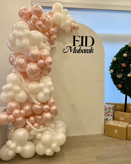 White oval Eid Mubarak backdrop with one-sided balloon garland in white and pearl pink (7ft x 4ft).