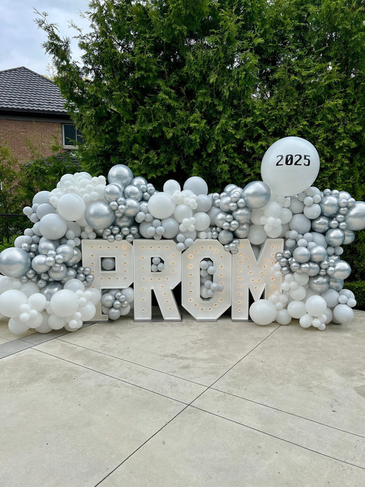 Decorative setup with 'PROM' letters and balloons on a patio