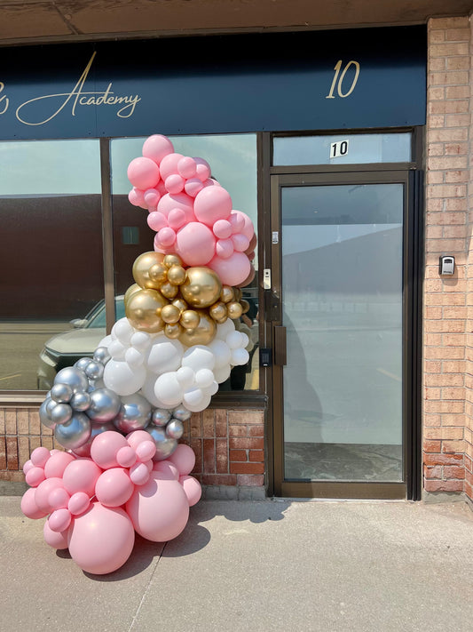 Elegant 8 ft balloon garland in pink, gold, white, and silver decorating a business entrance, perfect for salons or storefronts in the Greater Toronto Area.