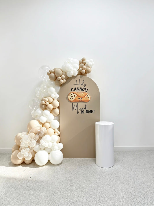 holy cannoli first birthday balloon backdrop with beige garland and cannoli cutout