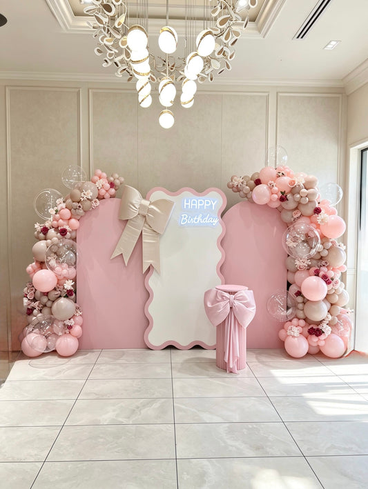 pink birthday backdrop with bow details and luxury balloon garlands