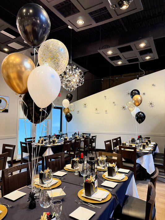 Five helium balloon centrepiece with black, gold, white, and confetti balloons for elegant dinner events.