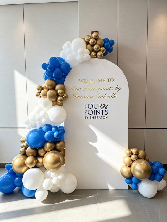 white full arch corporate backdrop with blue white and gold balloon garland