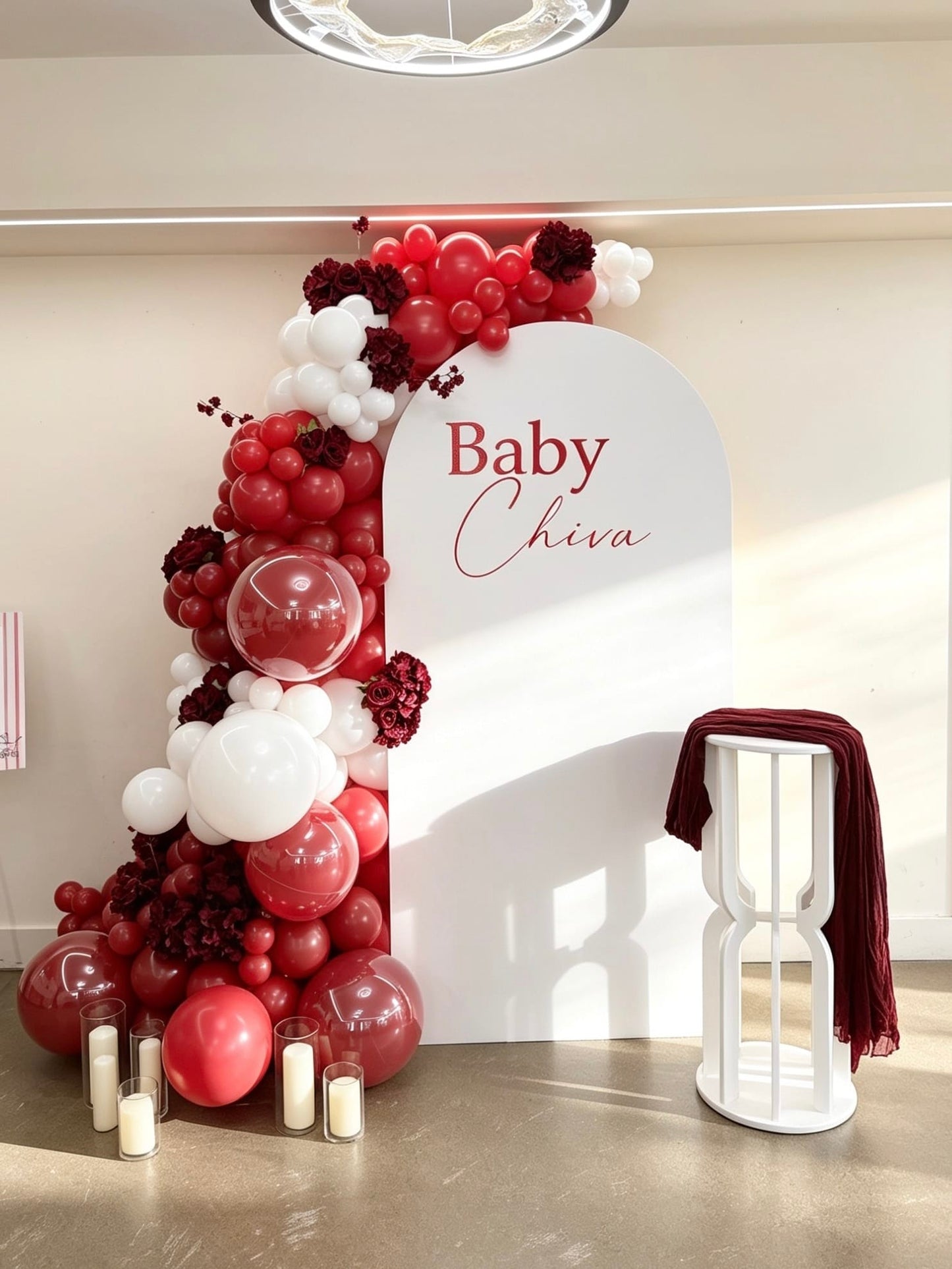 white full arch baby shower backdrop with ruby red and burgundy balloon garland