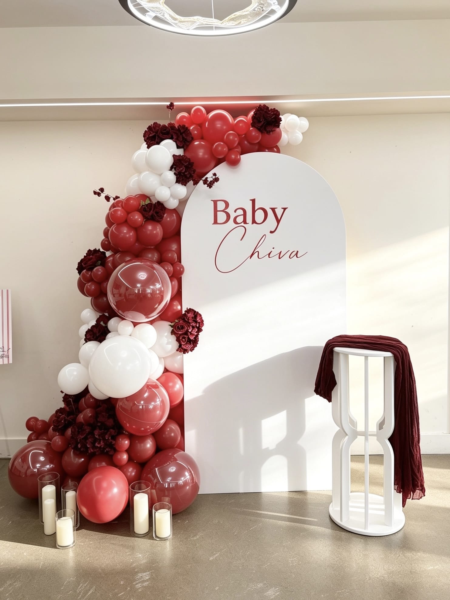 white full arch baby shower backdrop with ruby red and burgundy balloon garland