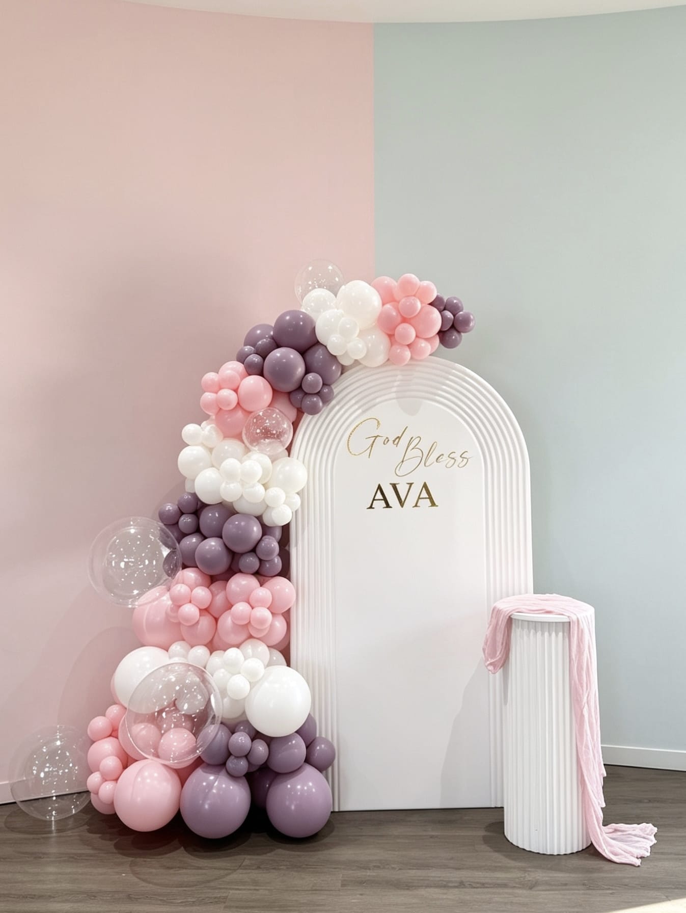 White ripple baptism backdrop with pink, lavender and white balloon garland and custom name lettering.