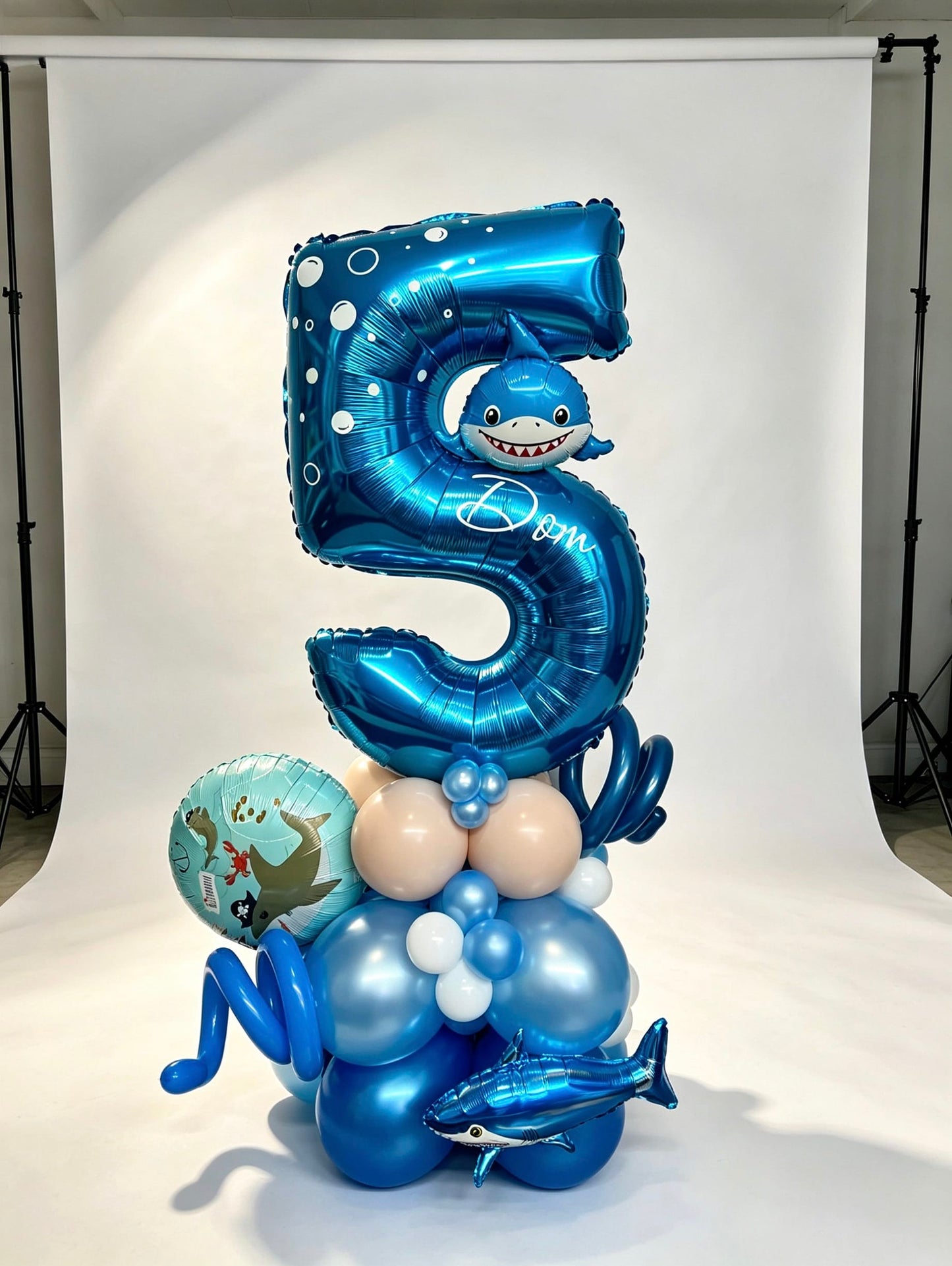 number stack balloon arrangement with foil number and themed balloons
