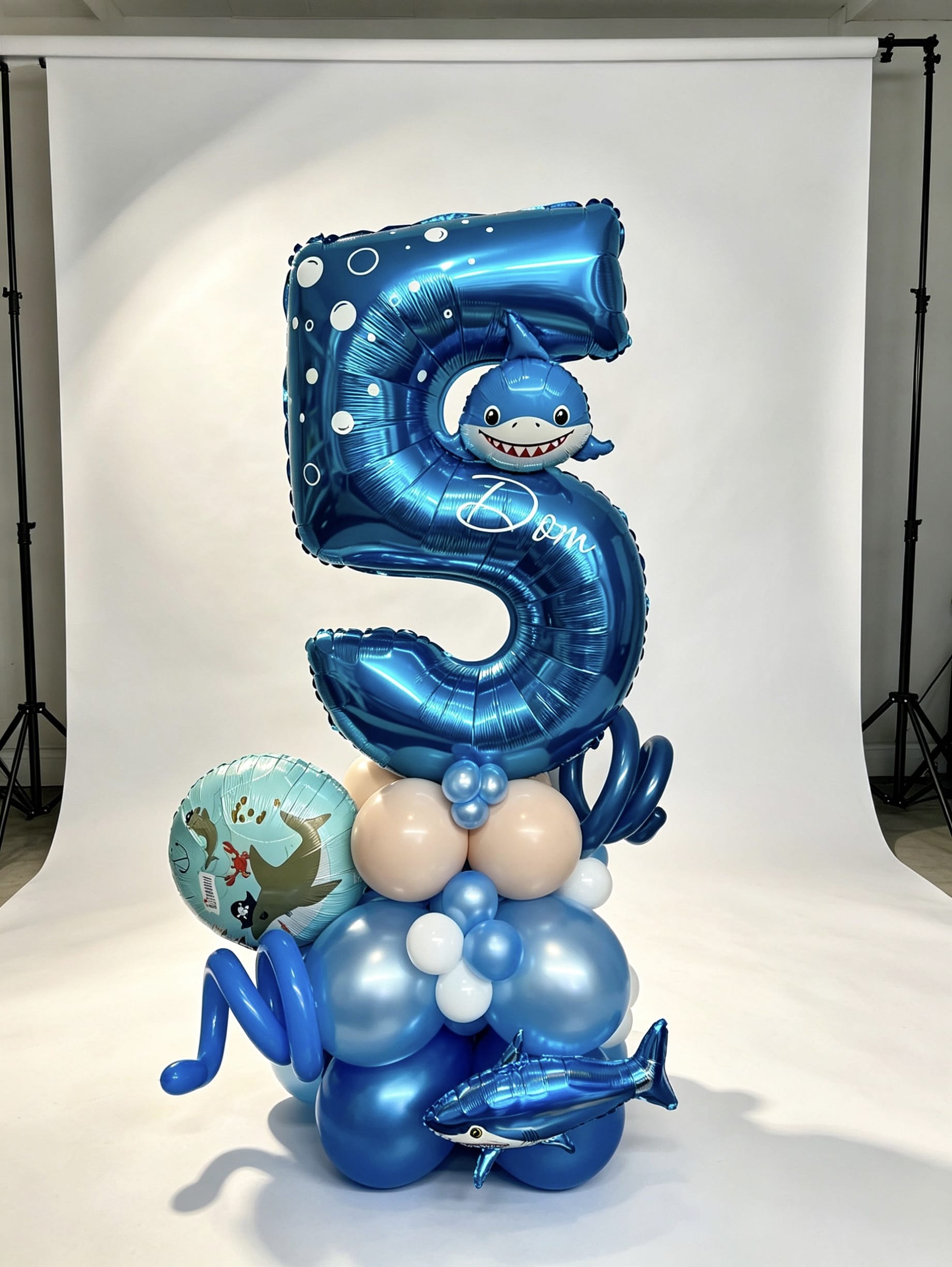 number stack balloon arrangement with foil number and themed balloons
