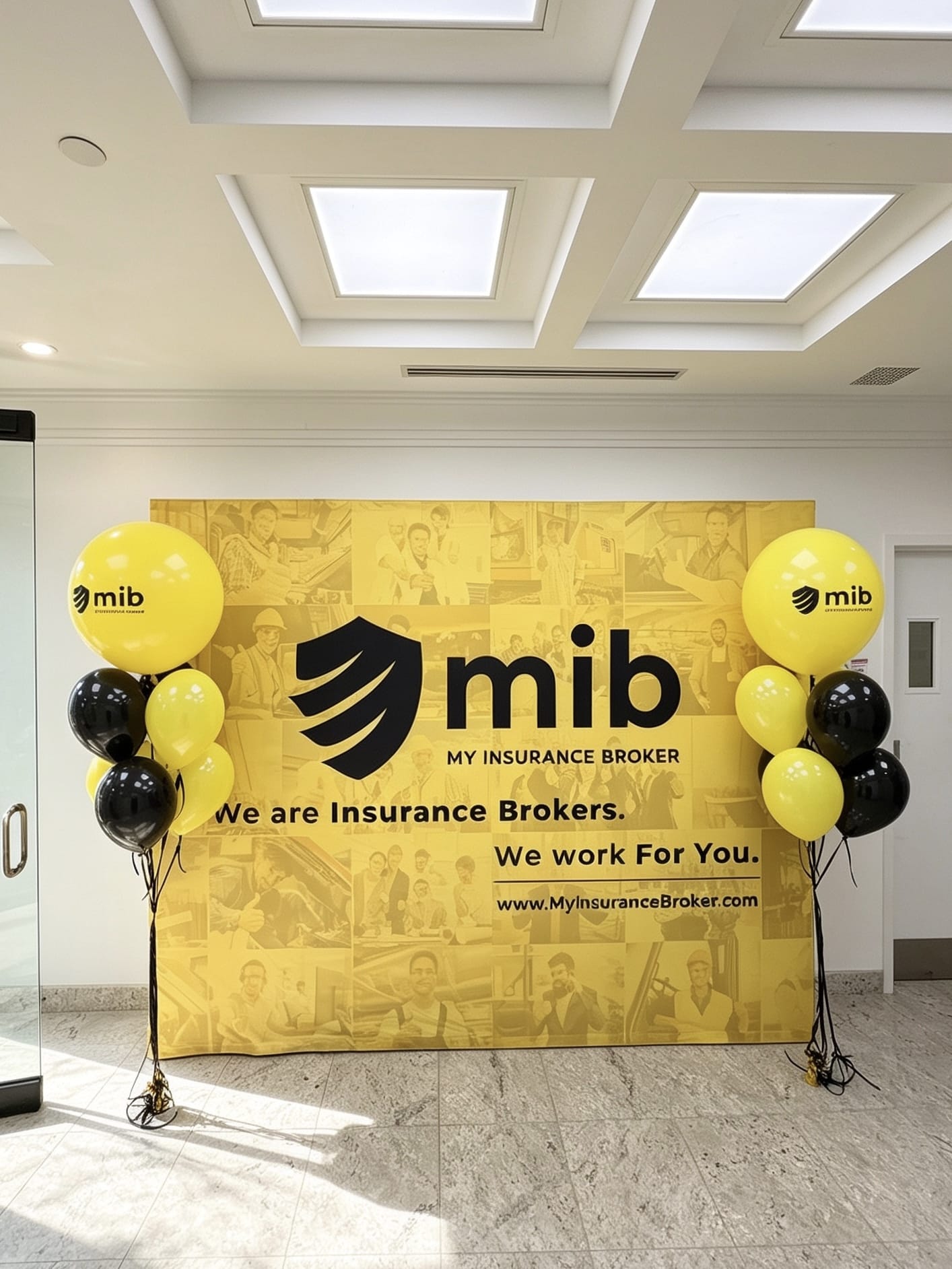 Two custom corporate balloon bouquets featuring branded yellow logo balloons with black and yellow accents.
