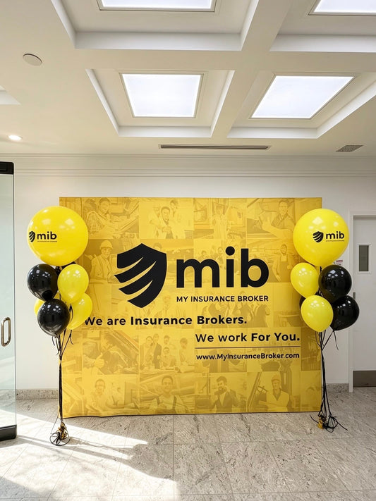 Two custom corporate balloon bouquets featuring branded yellow logo balloons with black and yellow accents.