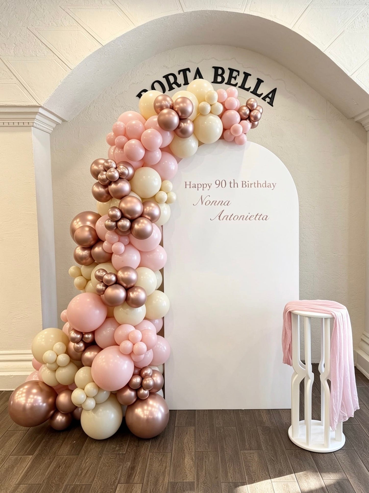 90th birthday backdrop with blush pink and rose gold balloon garland and white full arch backdrop