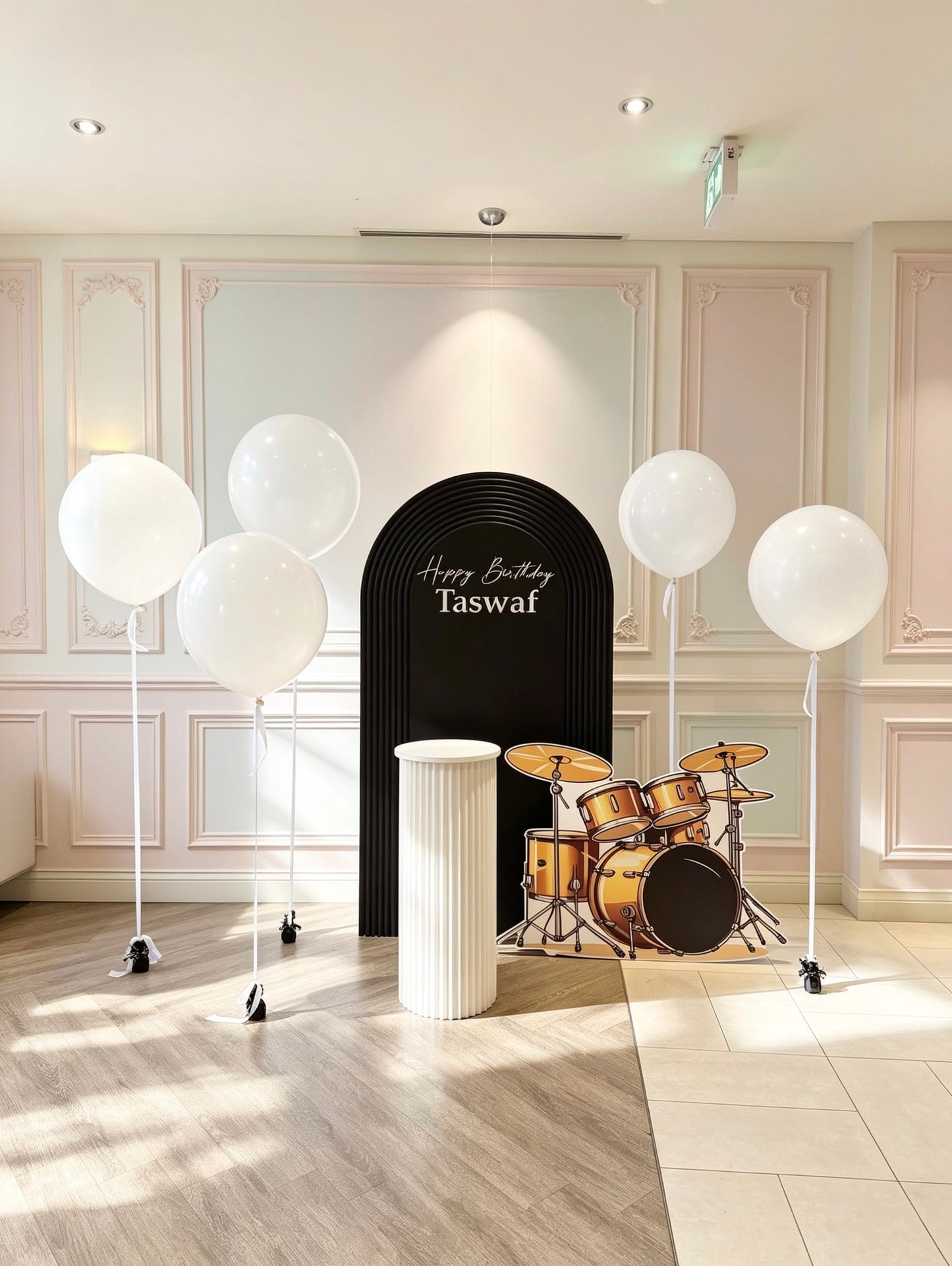 music themed birthday backdrop with black ripple arch white helium balloons and drum set cutout