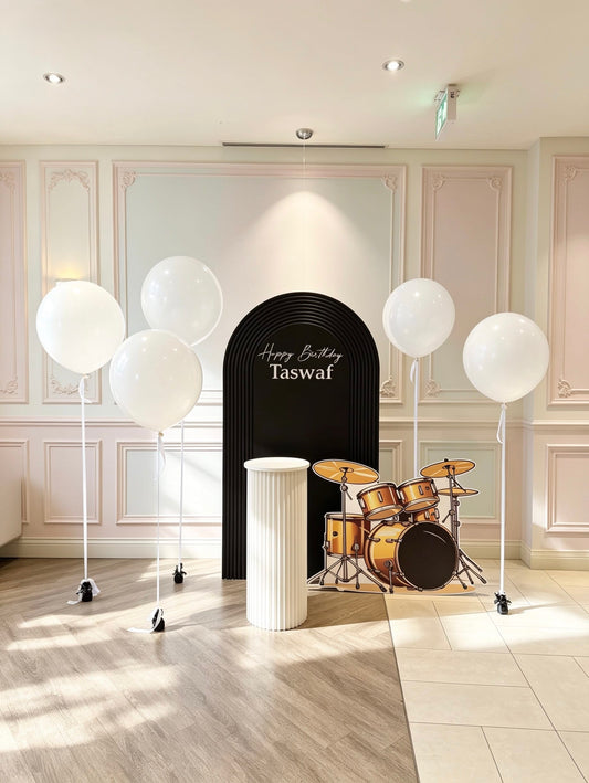 music themed birthday backdrop with black ripple arch white helium balloons and drum set cutout
