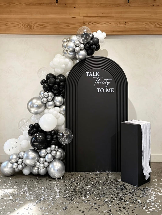 luxury black and silver 30th birthday backdrop with ripple arch and chrome balloons
