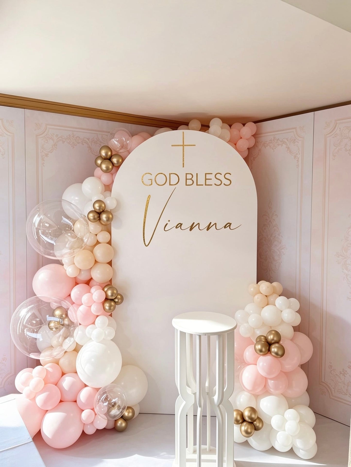 White communion arch backdrop with blush pink, white and gold balloon garlands, bubble balloons and pedestal stand