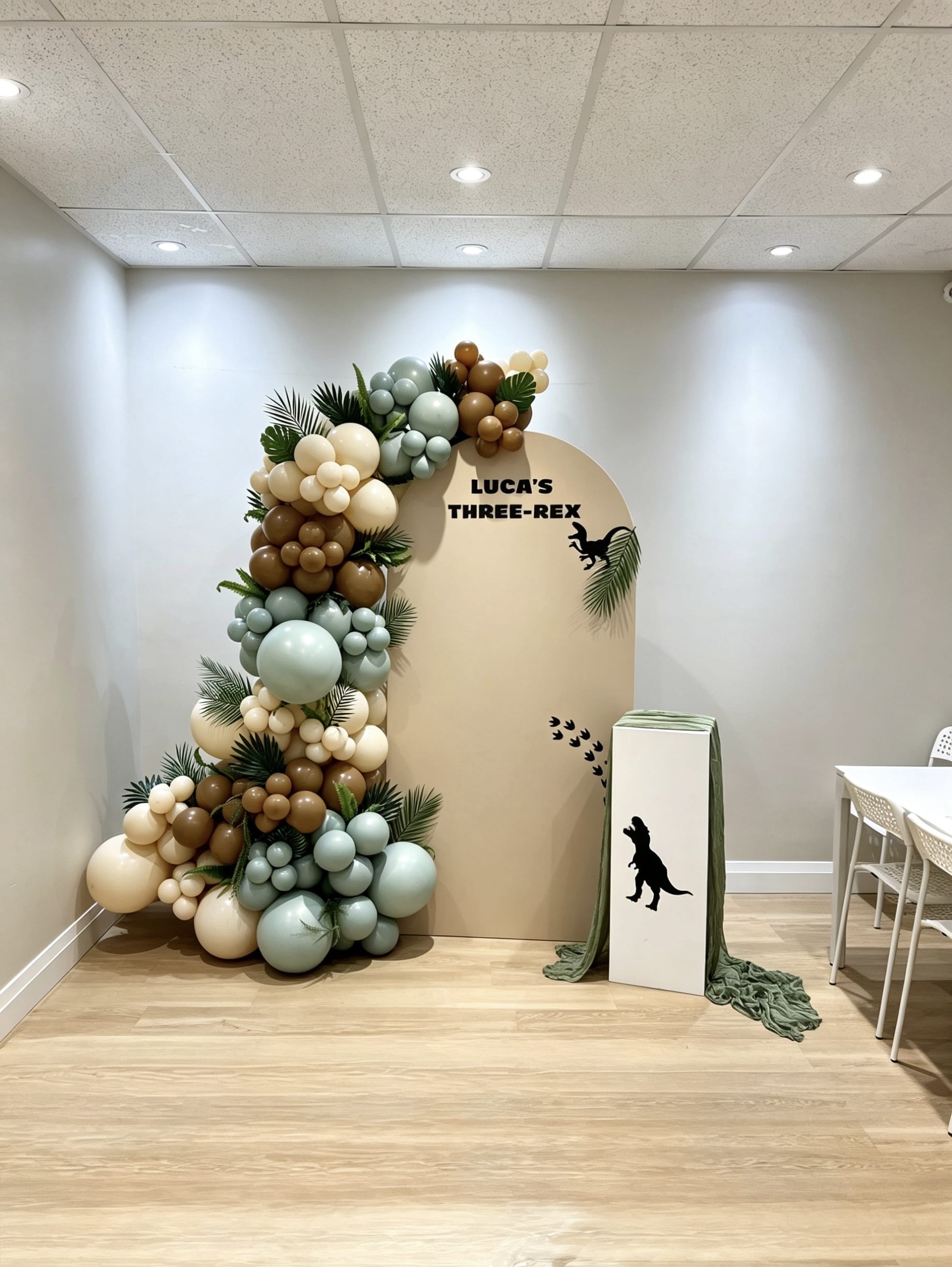 dinosaur birthday balloon backdrop with green garland and jungle decor
