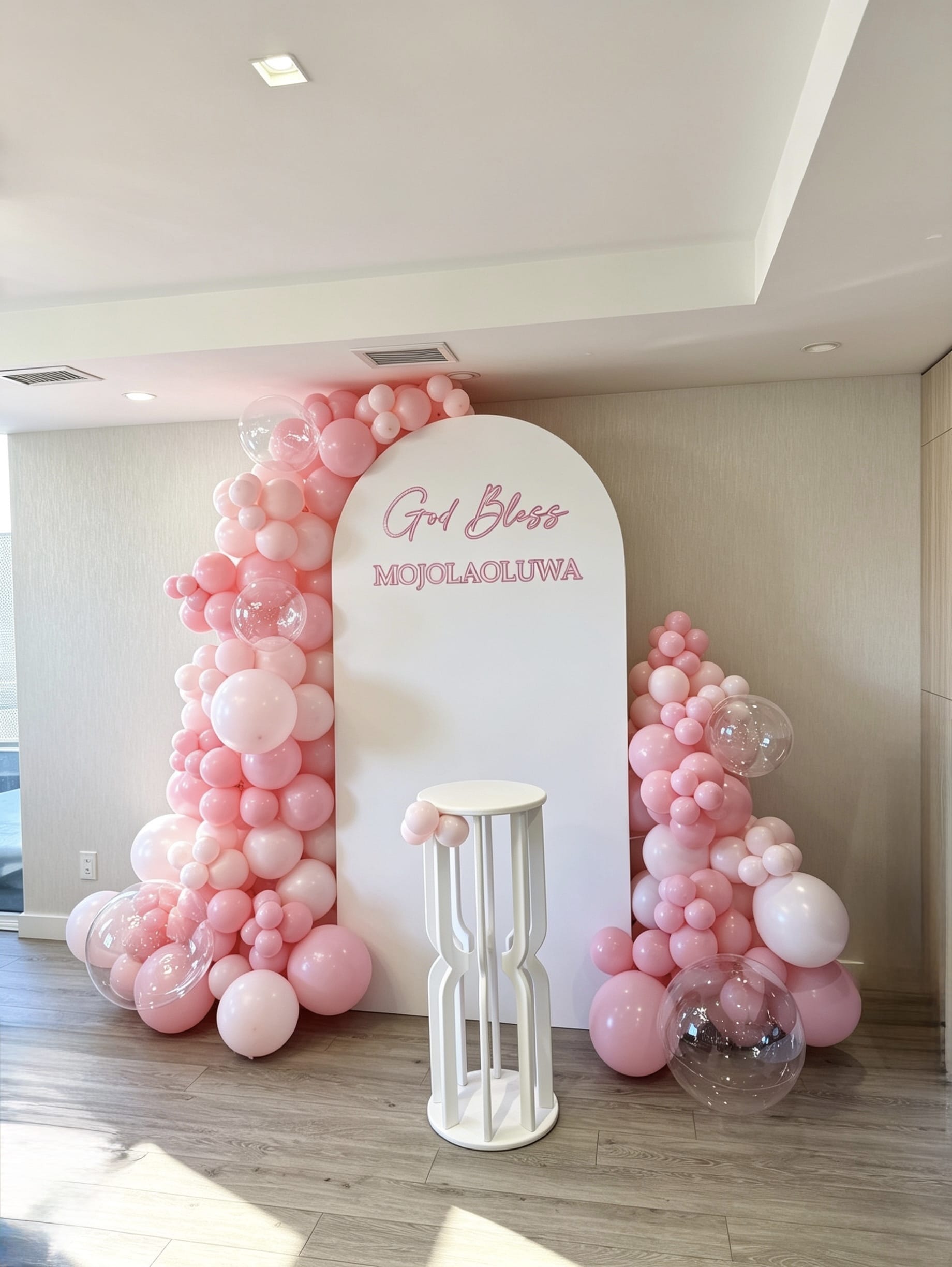 white full arch backdrop with monochrome pink balloon garland and clear bubble balloons