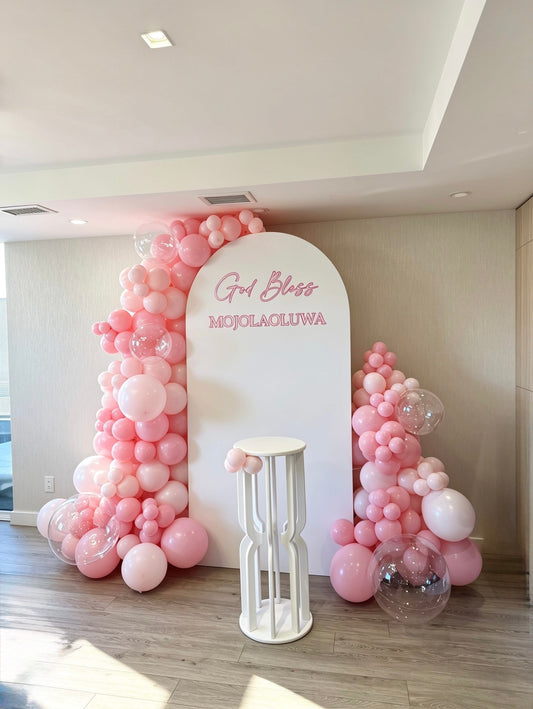 white full arch backdrop with monochrome pink balloon garland and clear bubble balloons