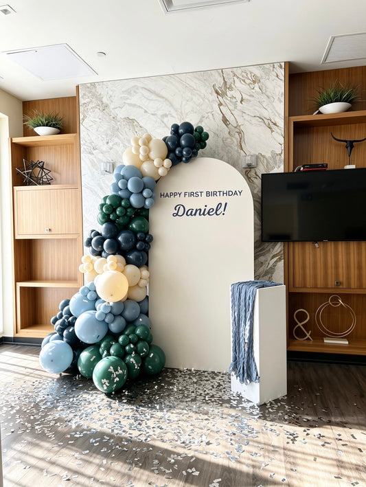 modern blue first birthday backdrop with luxury balloon garland and confetti