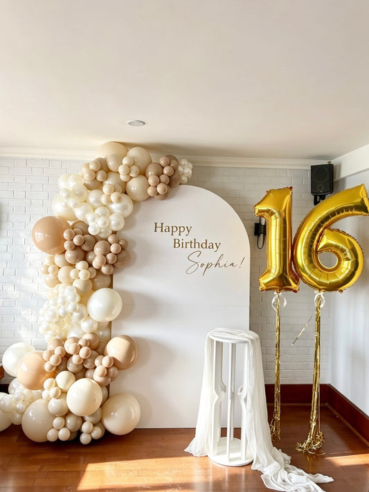 neutral sweet 16 balloon backdrop with pearl garland and floating number balloons