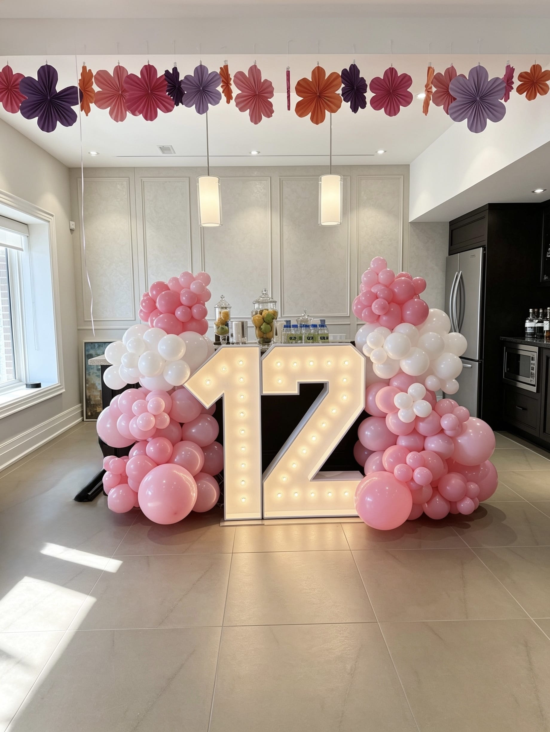 Pink and white balloon garlands with illuminated marquee number 12 setup