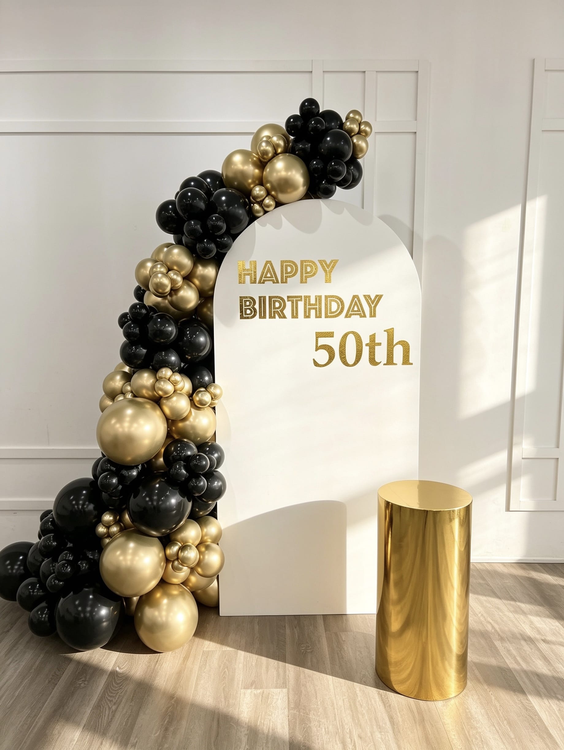 classic black and gold birthday backdrop with luxury balloon garland and gold pedestal