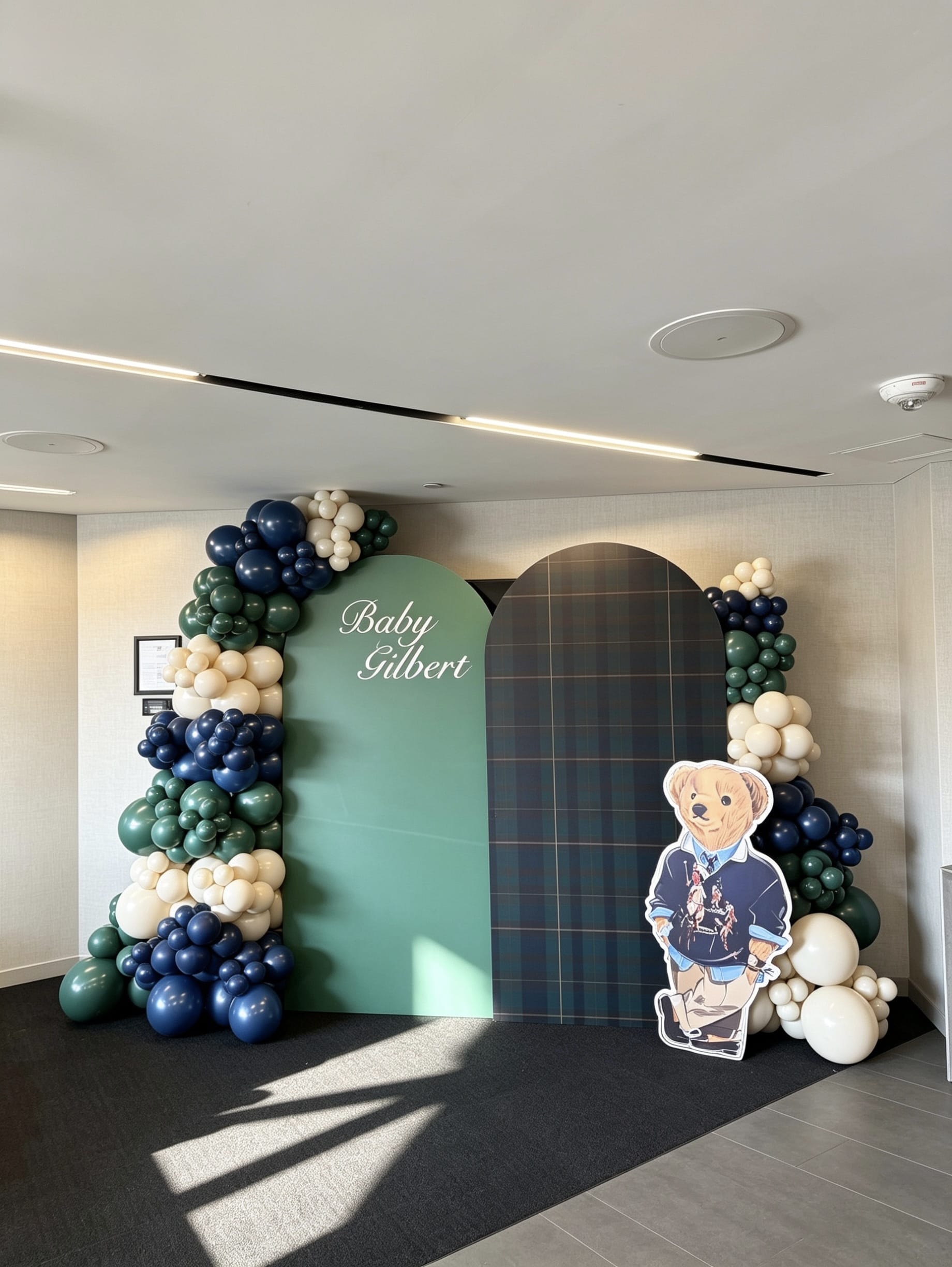 luxury polo inspired baby shower backdrop with tartan panels and navy green balloon garlands