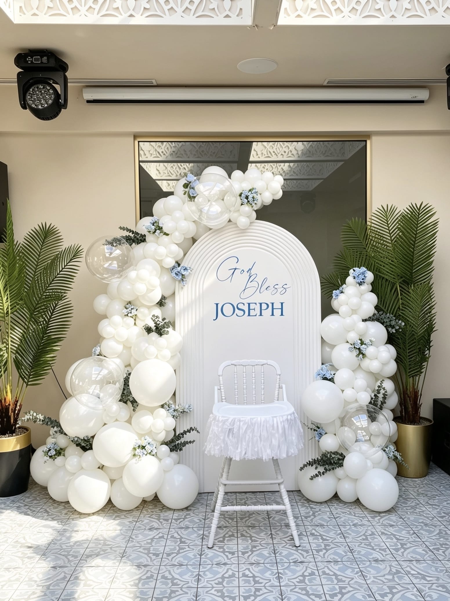 white baptism backdrop with ripple arch and elegant balloon garlands