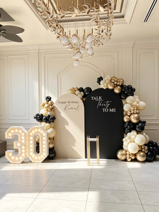 luxury black gold and ivory 30th birthday backdrop with marquee numbers and balloon garlands
