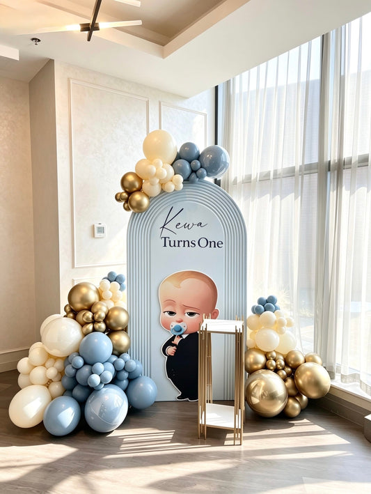 boss baby first birthday backdrop with blue and gold balloon decor