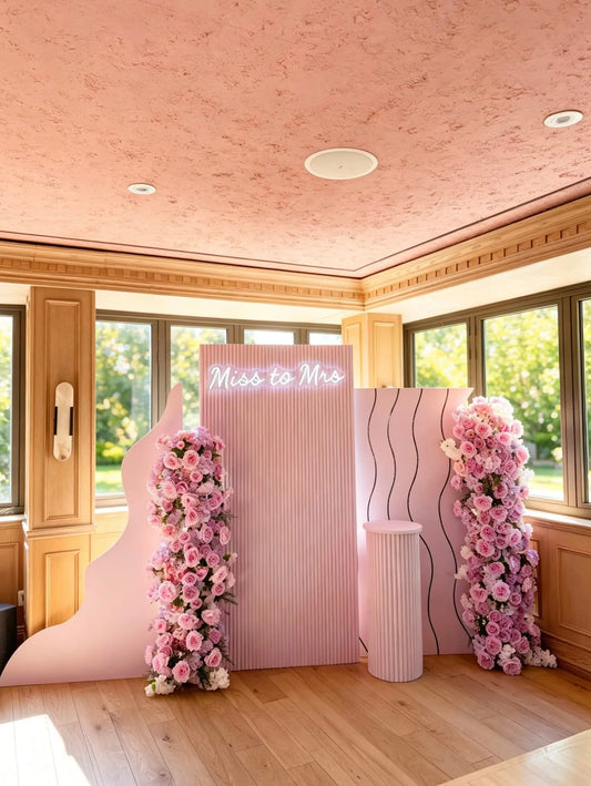 Lavender Miss to Mrs bridal shower backdrop with three statement panels, pink and lavender floral arrangements, illuminated sign and matching ribbed pedestal.