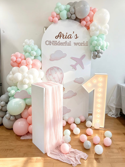 pastel first birthday backdrop with balloon garlands and marquee number one