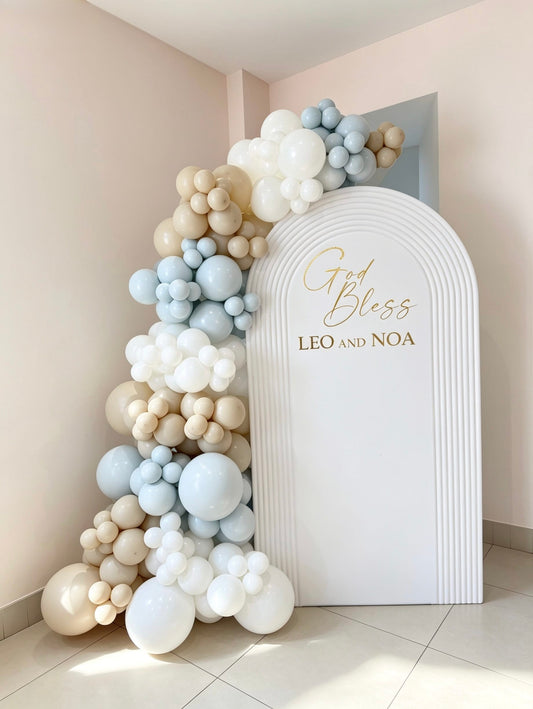 white hollow ripple arch backdrop with blue beige and ivory balloon garland for baptism celebration