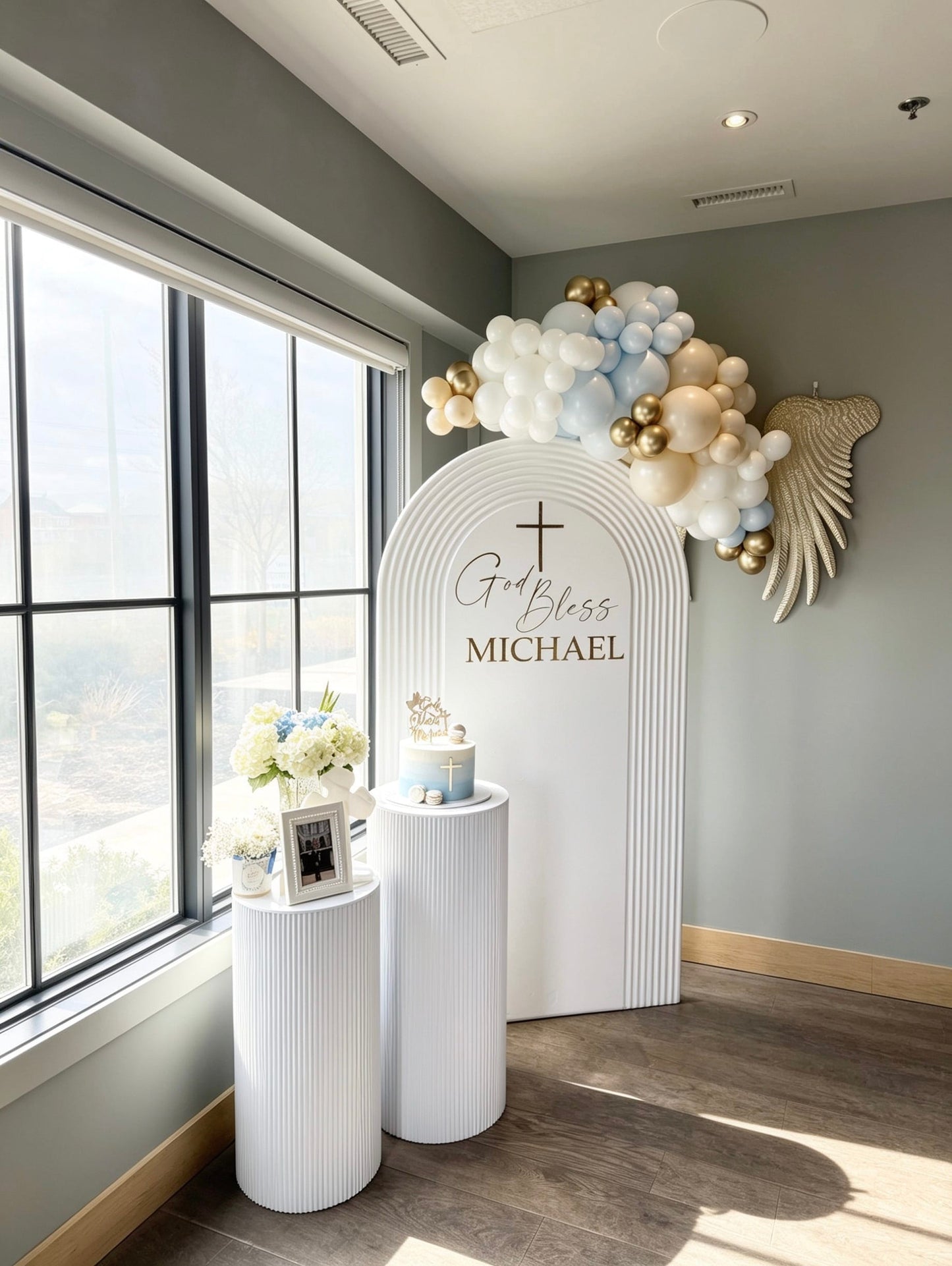 Blue and gold baptism backdrop with white ripple arch, custom name and balloon garland