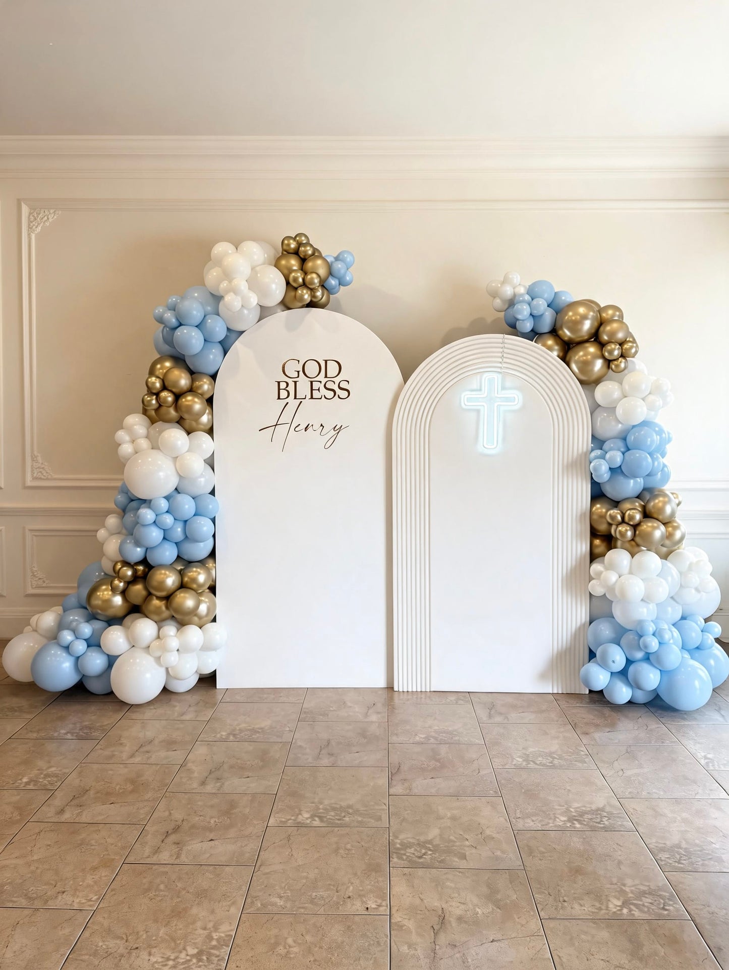 Double arch communion backdrop with illuminated cross and blue, white and gold balloon garlands.